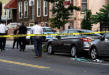 Lib City Mass Shooting – 7 Victims Police and crime scene tape on city street.