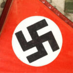 Two Nazi Soldiers Reappear As River Drops Close-up of a red flag featuring a black swastika symbol