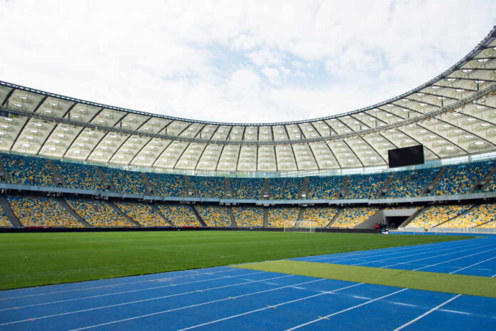 Empty stadium with blue running track and green field