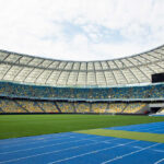 Empty stadium with blue running track and green field