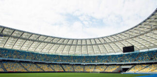 Empty stadium with blue running track and green field