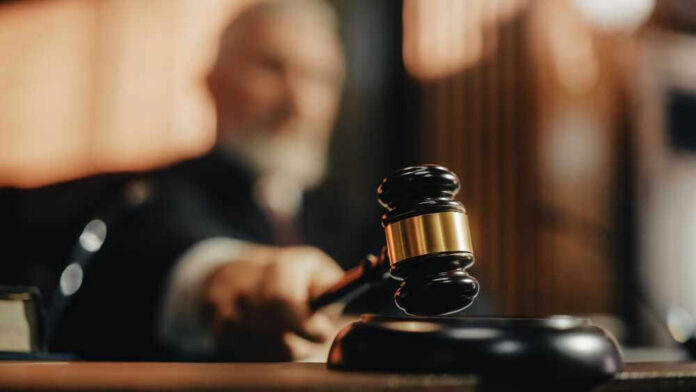 shutterstock_2056414424 Judge striking gavel in courtroom.