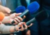 Costco’s Monster Head Causes Aisle Mayhem Reporters holding colorful microphones