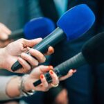 Dirty Soda Goes National Reporters holding colorful microphones