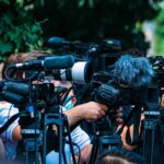 Congress Rebels – Trump Hits a Wall TV news cameras crowding together at an outdoor event
