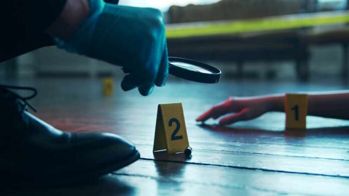 Detective,Collecting,Evidence,In,A,Crime,Scene.,Forensic,Specialists,Making A detective examining evidence at a crime scene with markers on the floor