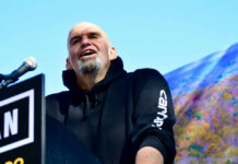 Dems Turn On Fetterman? John Fetterman speaking at podium.