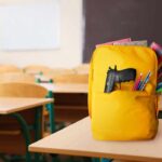 VIDEO: Eleven Students Gunned Down A yellow backpack with a gun partially visible in a classroom setting