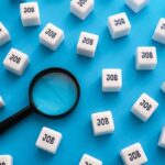 TODAY: Jobs Sputter Again — What’s Breaking? Magnifying glass among cubes labeled job on blue background