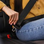 Person fastening a seat belt in a car