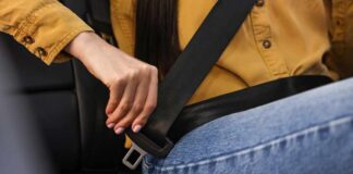 Person fastening a seat belt in a car
