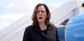 Kamala Harris speaking in front of airplane stairs.