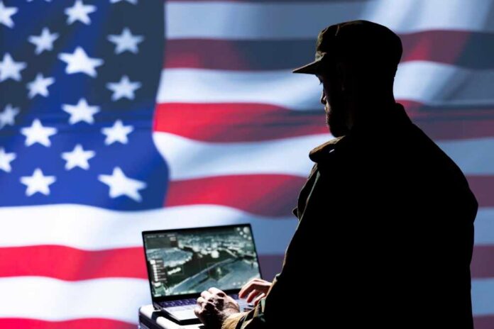 Silhouette of a person using a laptop before a large US flag