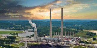 Coal-fired power plant with tall smokestacks at sunset