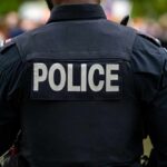 Graduation Turns Into Killing Ground Back view of a police officer wearing a uniform with 'POLICE' displayed