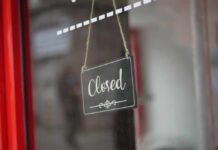 A closed sign hanging on a shop window