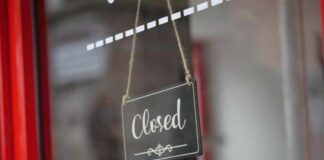 A closed sign hanging on a shop window