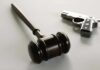 wooden judge's gavel with a handgun in the background