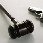 Insanity Claim Shredded In Chilling Shooting Case wooden judge's gavel with a handgun in the background