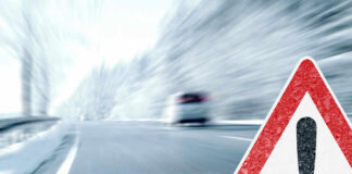 Road sign warning blurred highway scene