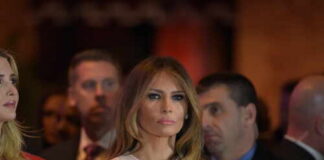 Melania Trump at an event with a crowd in the background