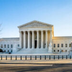 Supreme Court building with columns and U.S. flag