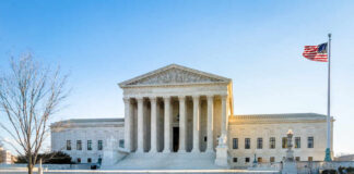 Supreme Court building with columns and U.S. flag