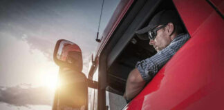 Truck driver looking out window at sunset.