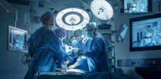 Josh Kline and Dontrelle Inman performing surgery with a medical team in an operating room