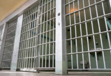 Outrage Erupts: Seven Years, Freedom Empty prison cell with metal bars and toilet.
