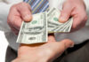 Election Cash: Checks Land Before Midterms Two hands exchanging cash bills