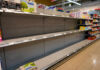 Empty supermarket shelves with sparse products displayed