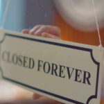 Closed forever sign being placed on window.