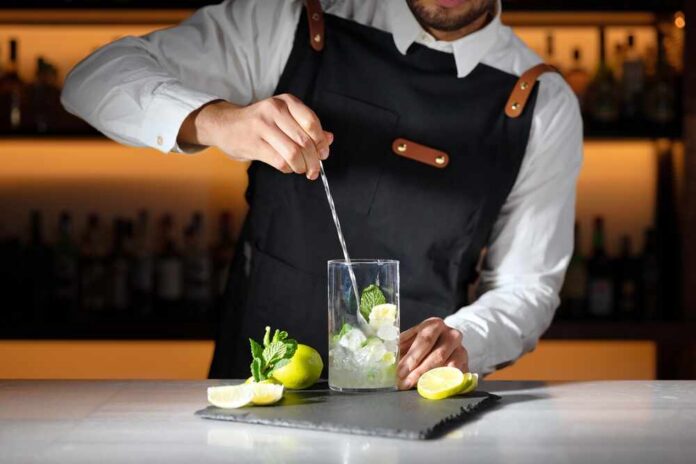 Barman,Preparing,Mojito,Cocktail.,High,Quality,Photography. Interior of a cozy restaurant with wooden tables and decorative plants