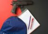 Close-Range Horror Inside A Classroom Handgun beside school supplies and a blue backpack