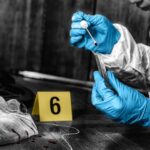 Forensic investigator collecting a blood sample at a crime scene