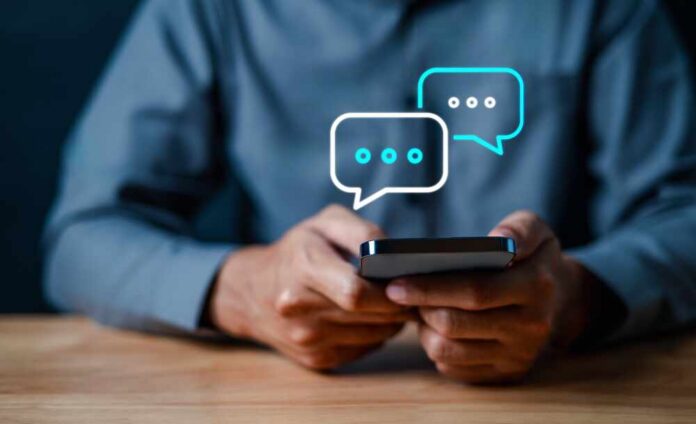 Technology,,Communication,,Social,Media,Text,Messaging,Concepts,,Businessman,Using,Smartphone Person holding a smartphone with chat bubbles above