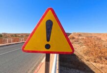 Surrogacy Mansion Horror Caught On Camera Triangular warning road sign with exclamation mark on a rural highway