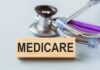 Surprise Cash Hits Medicare – But Not Everyone Wooden block with MEDICARE text next to a stethoscope