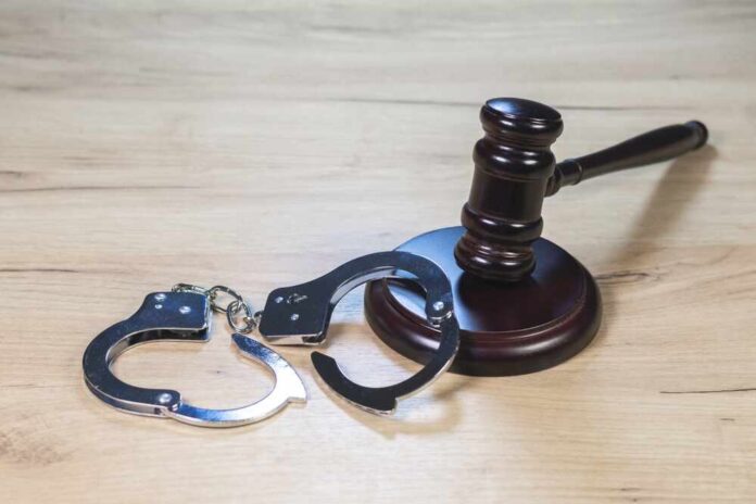 Judge,Hammer,For,Adjudication,With,Wooden,Stand,And,Handcuff.,Auction Gavel and handcuffs on wooden table