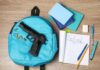 Parents Outraged: Daycare, Gun, 15 Seconds A blue backpack with a handgun and school supplies on a wooden surface