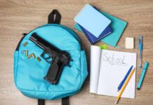 Parents Outraged: Daycare, Gun, 15 Seconds A blue backpack with a handgun and school supplies on a wooden surface