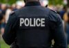 Chilling Ambush Stuns Police Back view of a police officer wearing a uniform with 'POLICE' displayed
