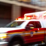 Ambulance with flashing lights speeding through a city street