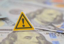 $1M Heist Impacts Americans A warning sign placed on top of U.S. dollar bills