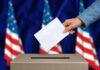 Ballots Seized – Citizens Flagged Hand casting a vote into a ballot box.