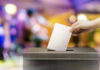 ELECTION CRIME: DOJ Targets State Hand placing ballot in voting box.